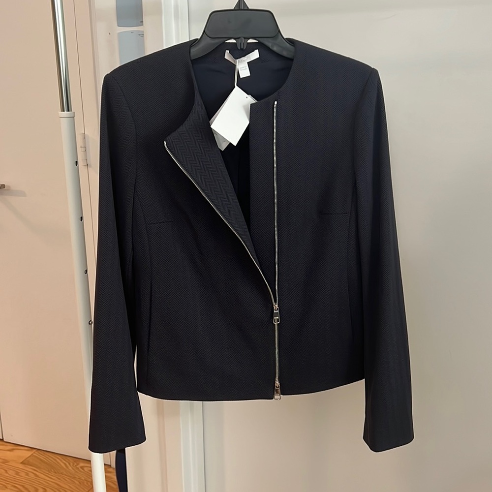 Navy Blue woman’s suit jacket. New with tags size 6. Zipper in middle detail.